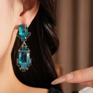Primer plano de pendientes vintage de oro con grandes piedras azules usados en oreja