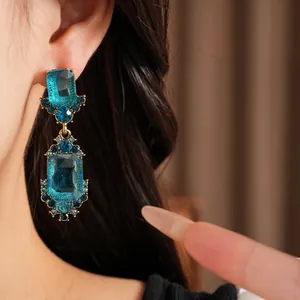 Detalle de pendientes vintage con piedras preciosas azules y engaste dorado