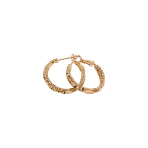 Elegant gold hoop earrings with faceted geometric cut texture and silver needle post.