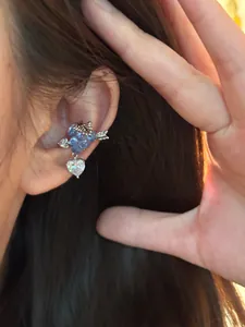 Dettaglio dell'orecchino a clip con uva e cuore in zircone indossato sull'orecchio