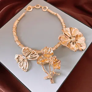 Dettaglio di un girocollo dorato vintage con grandi motivi di fiori e farfalle in metallo