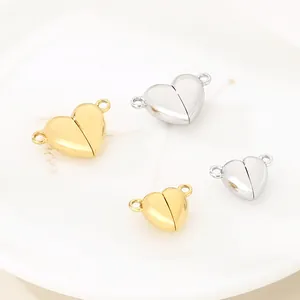 Primo piano di chiusure magnetiche a cuore in acciaio inossidabile, finiture oro e argento.