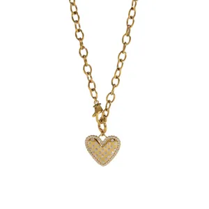 Gold-tone stainless steel heart pendant necklace with shimmering crystal accents.