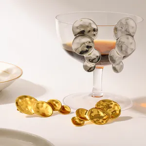 Detailansicht großer unregelmäßiger strukturierter Scheibenohrringe in Gold und Silber
