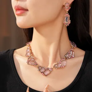 Dettaglio ravvicinato di collana e orecchini geometrici rosa di lusso su modella