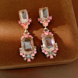 Vista dettagliata di eleganti orecchini geometrici rosa con cristalli e strass brillanti.