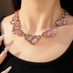 Primo piano di una collana geometrica con strass rosa sul collo
