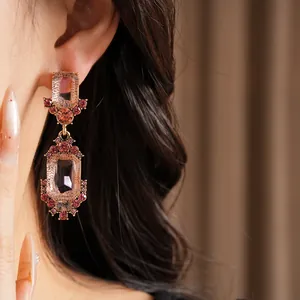 Primo piano di orecchini vintage con cristalli rosa indossati con stile elegante