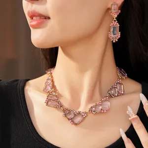 Elegante set di gioielli geometrici con strass rosa, collana e orecchini indossati