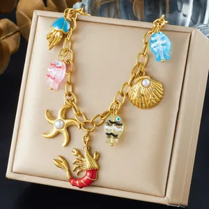 Gold plated ocean theme necklace featuring shell, starfish, and lobster charms