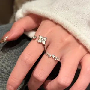 Vue rapprochée du design floral délicat des bagues en argent avec incrustation de nacre.