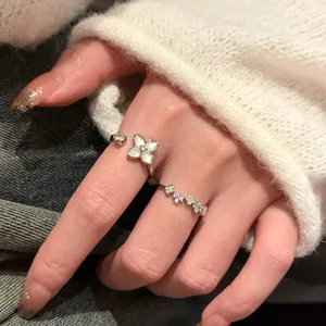 Détail de bagues élégantes en argent avec motifs de fleurs en nacre sur une main féminine