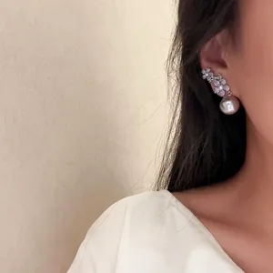 Gros plan de boucles d'oreilles élégantes en zircone fleur avec perle sur un mannequin