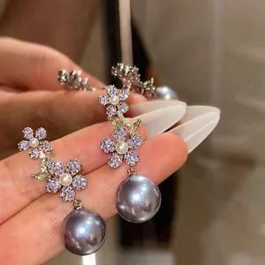 Vue détaillée de boucles d'oreilles fleur vintage avec zircon violet et perles