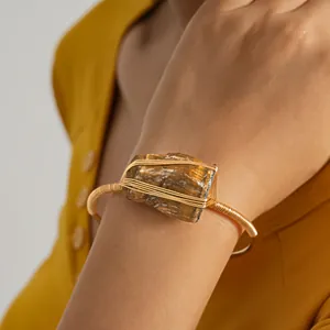 Detail van natuurlijke ruwe steen met goudkleurige draad gewikkelde armband