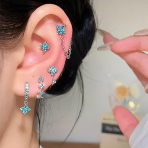 Elegant light blue zircon flower earring set showcased on a model's ear with shiny details