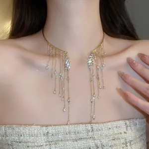 Close-up of elegant gold collar necklace with sparkling crystal fringe on model