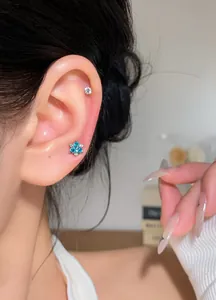 Close-up of blue zircon flower earring on model's ear showing elegant design