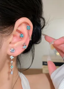 Close-up of elegant silver earrings with blue zircon flowers and star dangles