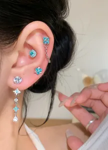 Close-up of elegant silver needle earrings with blue zircon flowers