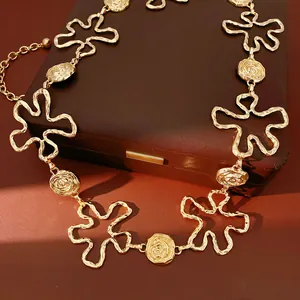 Détail d'une chaîne de taille réglable en métal doré avec motif de fleurs évidées