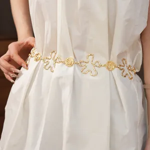 Gros plan d'une chaîne de taille dorée avec motifs de fleurs et de roses