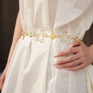 Vue détaillée des maillons de fleurs et de roses dorées de cette ceinture de taille élégante