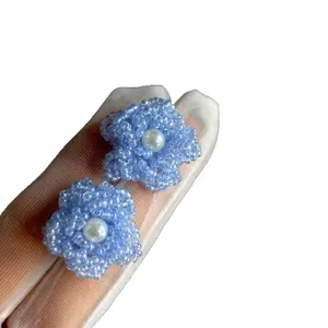 Élégantes boucles d'oreilles fleur en perles bleu clair avec centre en perle blanche