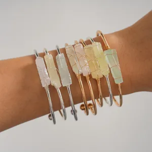 Dettaglio di diversi bracciali rigidi con cristalli naturali irregolari avvolti