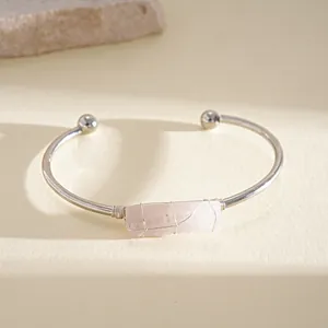 Vista dettagliata di quarzo rosa irregolare avvolto su un bracciale rigido argento