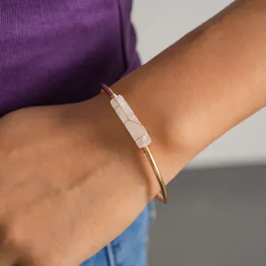 Vista dettagliata di un elegante bracciale in oro con pietra di quarzo bianco grezzo
