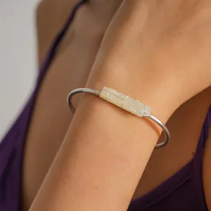 Primo piano di un bracciale rigido in argento minimalista con pietra di cristallo