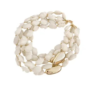Collier multicouche en acrylique avec perles blanches et accents géométriques dorés pour vacances.