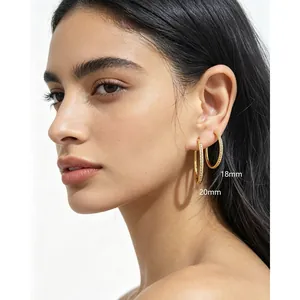 Model trägt vergoldete S925-Silber-Creolen mit Zirkonia in 18 mm und 20 mm Größe.