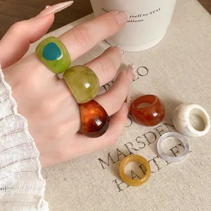 Close-up detail of stylish irregular resin rings with marble texture in various colors