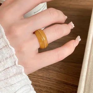 Detailed macro shot of a honey yellow resin ring with irregular dye texture and gold bead line