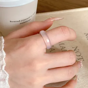 Close-up of a translucent lavender purple resin ring worn on a finger in a lifestyle setting.