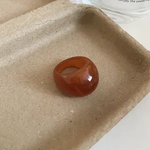 Macro view of a chunky amber resin ring showcasing its unique marbled texture and glossy finish