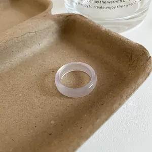 Detailed macro view of a translucent lavender resin ring on a textured paper tray.