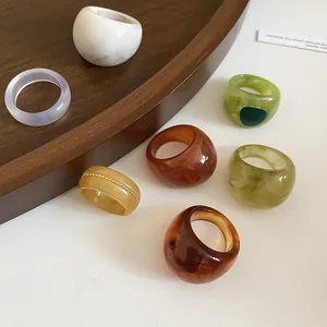 Collection of translucent resin rings with irregular swirl textures and marble patterns