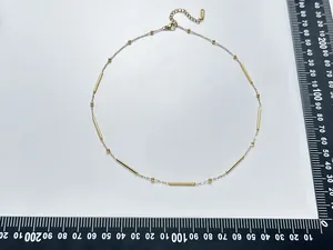 Primer plano del collar de nudos de bambú dorado mostrando medidas en la escala