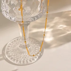 Detalle de un collar de cadena de cuentas y tubo de bambú de acero inoxidable bañado en oro