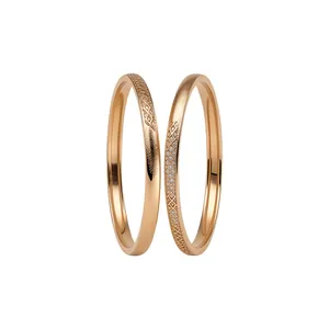 Pair of minimalist rose gold matte bangles with elegant hollowed-out diamond patterns