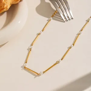 Primer plano detallado de un elegante collar dorado estilo bambú con perlas blancas finas