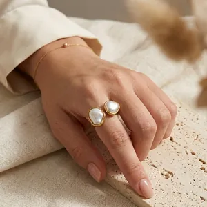 Close-up of a French retro irregular open ring with baroque pearls on a model's hand