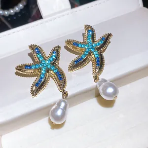 Dettaglio macro di orecchini vintage a stella marina con strass blu e gocce di perle