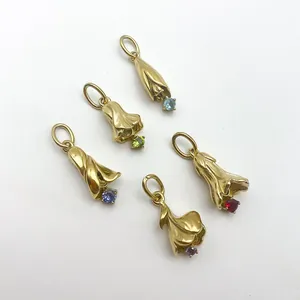 Vue détaillée de cinq pendentifs muguet dorés ornés de pierres de naissance colorées.