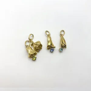 Gros plan sur des pendentifs fleur de lys dorés avec pierres de naissance pour bijoux DIY.