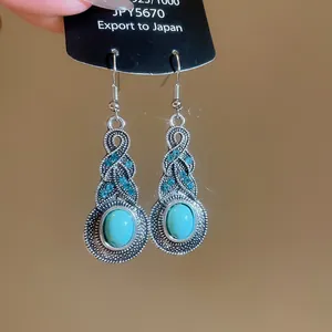 Dettaglio ravvicinato di orecchini vintage argentati con turchese e cristalli blu