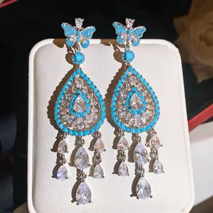 Eleganti orecchini pendenti con design a farfalla e goccia e pietre turchesi